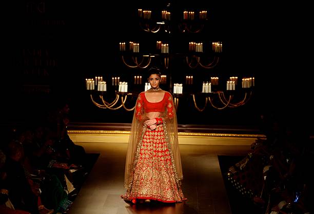Indian Bollywood actress Alia Bhatt presents a creation by Indian fashion designer Manish Malhotra during the India Couture Week 2014 in New Delhi on July 19, 2014. AFP PHOTO/ SAJJAD HUSSAIN        (Photo credit should read SAJJAD HUSSAIN/AFP via Getty Images)